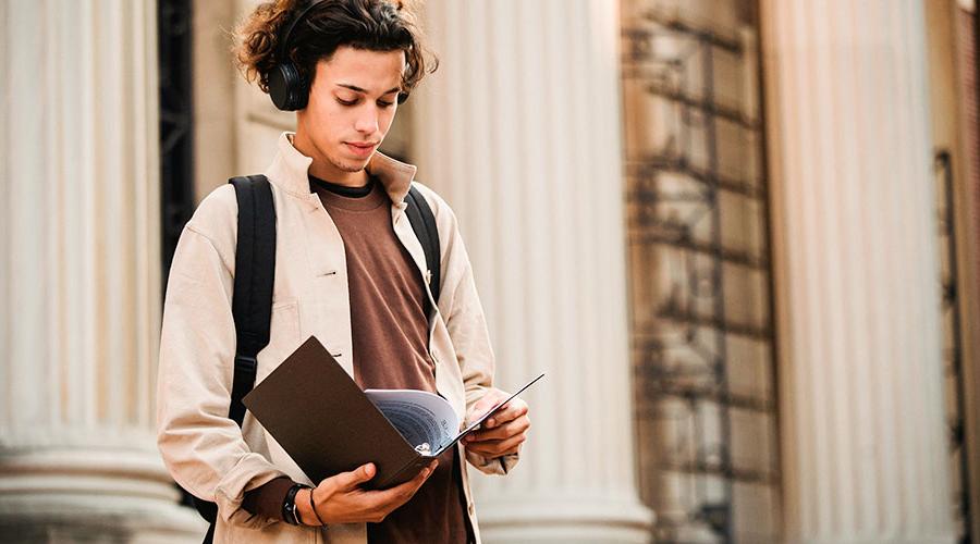 young male student holding his transcript